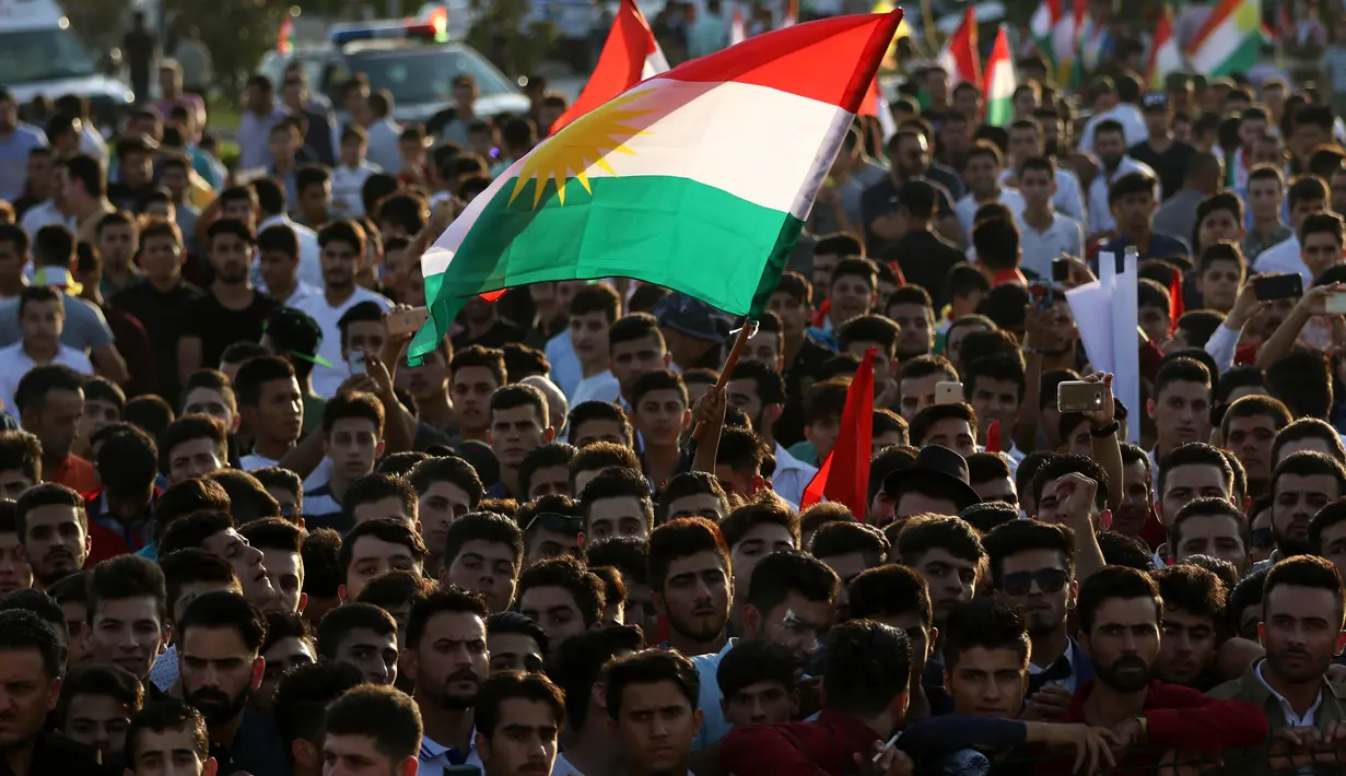 Warga Kurdi Irak berkumpul sambil mengibarkan bendera Kurdi saat melakukan aksi untuk meminta referendum kemerdekaan di Arbil, Irak utara (13/9). (AFP Photo/SAfim Hamed)