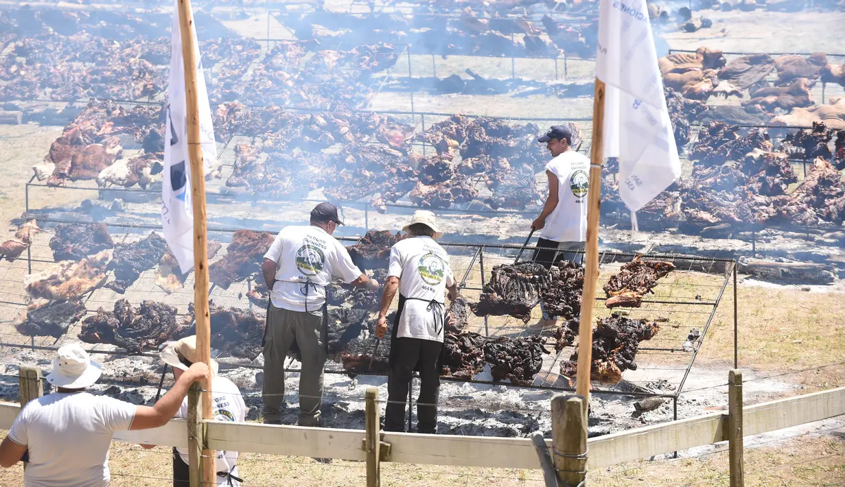 Peserta memanggang daging sapi sebanyak 16.500 kg di Taman Rodo di Minas, Uruguay (10/12). Dengan daging sebanyak 16.500 kg, mereka berusaha memecahkan rekor dunia dengan katagori  "The World's Biggest Barbecue". (AFP Photo/Miguel Rojo)