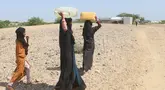 Perempuan pengungsi internal Yaman berjalan menuju tempat penampungan air untuk mengisi jeriken mereka di Distrik Abs, Provinsi Hajjah, Yaman, 10 Oktober 2026. (Essa Ahmed/AFP)