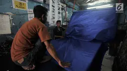 Aktivitas pekerja saat menyelesaikan sablon bendera partai politik di Percetakan Andalas Jaya, Jakarta, Rabu (2/1). Pedagang mengaku pemesanan naik hingga 60 persen dari bulan biasa. (Merdeka.com/Iqbal Nugroho)