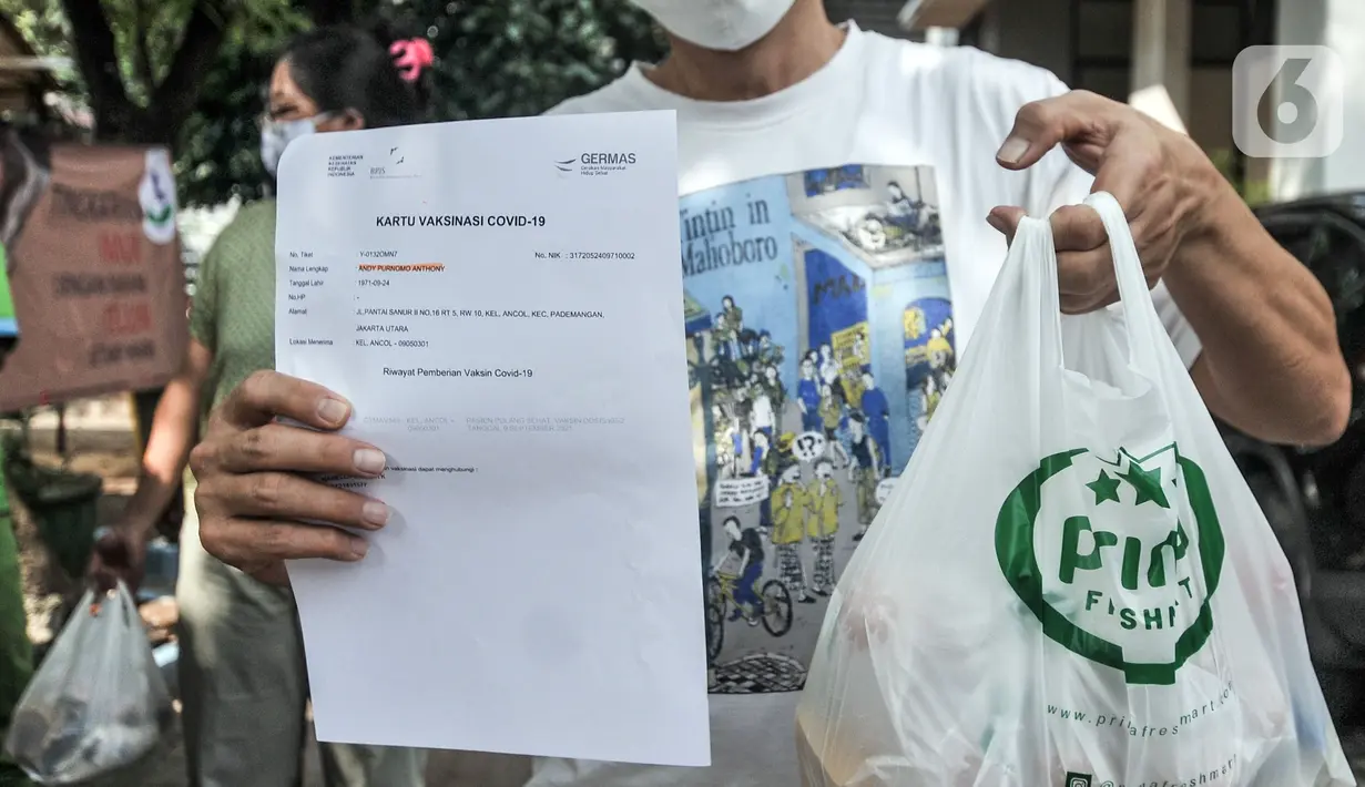 Warga menunjukkan sertifikat dan sembako usai mengikuti vaksinasi COVID-19 di Kantor Kelurahan Ancol, Jakarta, Kamis (17/6/2021). LMK Kelurahan Ancol membagikan sembako secara gratis kepada peserta vaksinasi COVID-19. (merdeka.com/Iqbal S. Nugroho)