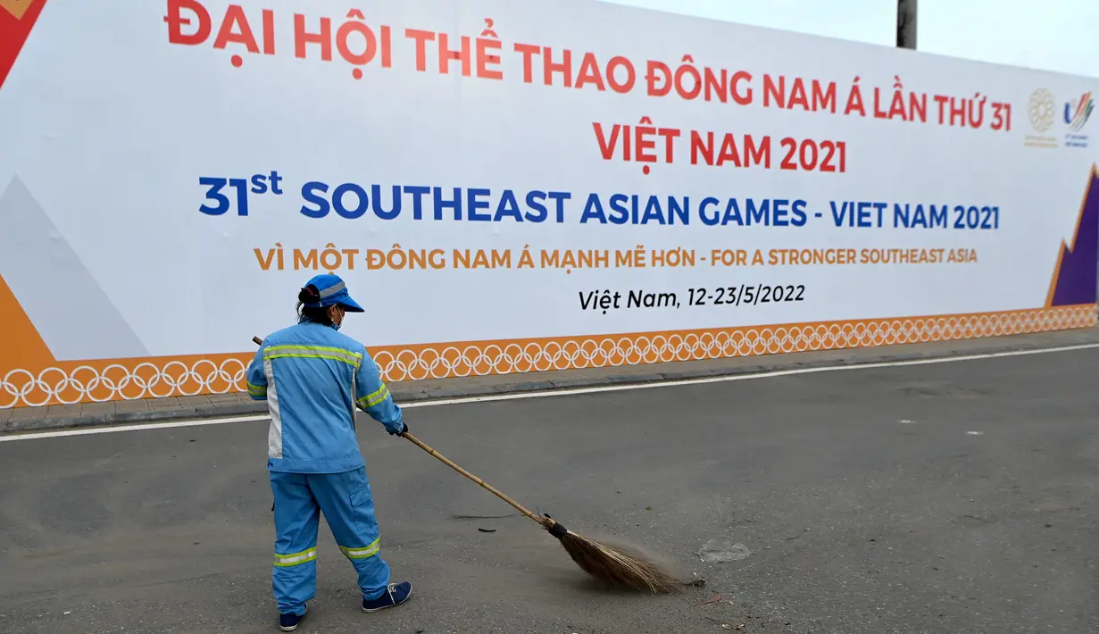 <p>Seorang pekerja menyapu sampah di depan tanda Pesta Olahraga Asia Tenggara (Southeast Asian Games) atau biasa disingkat SEA Games ke-31, sehari sebelum upacara pembukaan di Hanoi, Vietnam, Rabu (11/5/2022). SEA Games 2021 akan dibuka pada 12 Mei 2022 di Stadion My Dinh dengan mempertandingkan 40 cabang olahraga (cabor) dalam 526 nomor. (TANG CHHIN Sothy / AFP)</p>