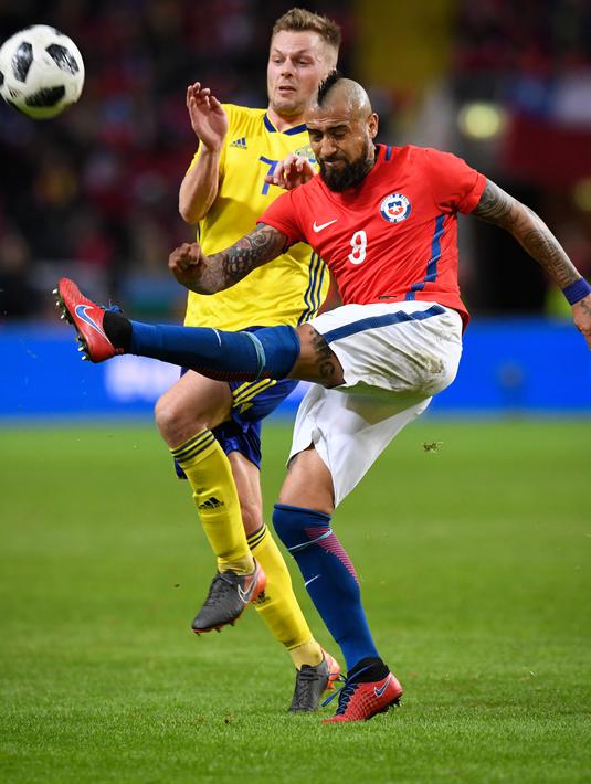 Gelandang Chile, Arturo Vidal berusaha membuang bola dari kawalan gelandang Swedia, Sebastian Larsson saat bertanding pada pertandingan persahabatan internasional Friends di Arena, Stockholm, (24/3). Chile menang 2-1. (Anders Wiklund/TT via AP)