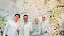 Hadiri pernikahan Irish Bella, Dhini Aminarti tampil simple denga dress panjang berlengan balon. Outfit serba putih ini dipadu dengan hijab panjang berwarna putih [@dhiniaminarti]