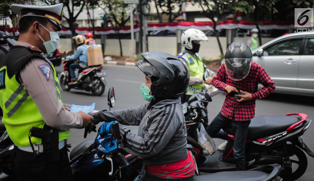 Polisi lalu lintas melakukan tilang terhadap pengendara motor saat razia Operasi Patuh Jaya 2019 di kawasan Kemanggisan, Jakarta, Kamis (29/8/2019). Diketahui, Operasi Patuh Jaya 2019 di wilayah hukum Polda Metro Jaya mulai digelar hari ini hingga 11 September 2019. (Liputan6.com/Faizal Fanani)