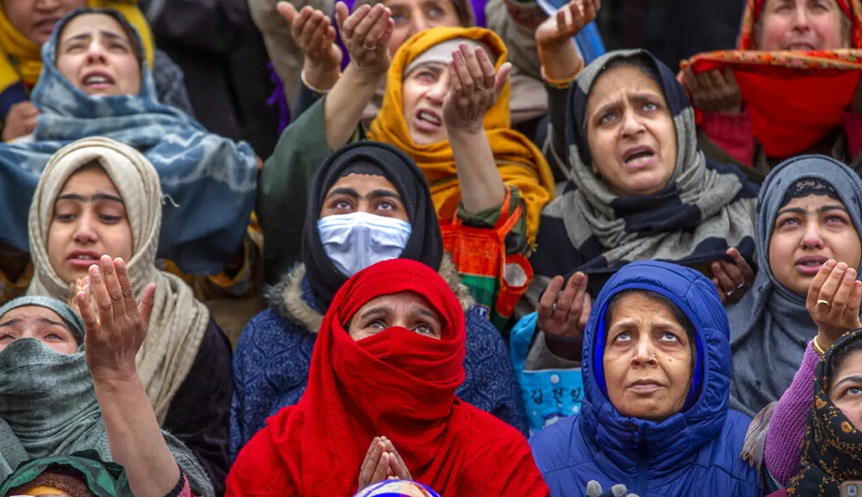 Para wanita muslimah memanjatkan doa saat imam memamerkan peninggalan Nabi Muhammad pada peringatan Isra Miraj di Masjid Hazratbal, Srinagar, Kashmir, India, Jumat (12/3/2021). Ribuan muslim Kashmir berkumpul di Masjid Hazratbal yang menyimpan janggut Nabi Muhammad. (AP Photo/Dar Yasin)