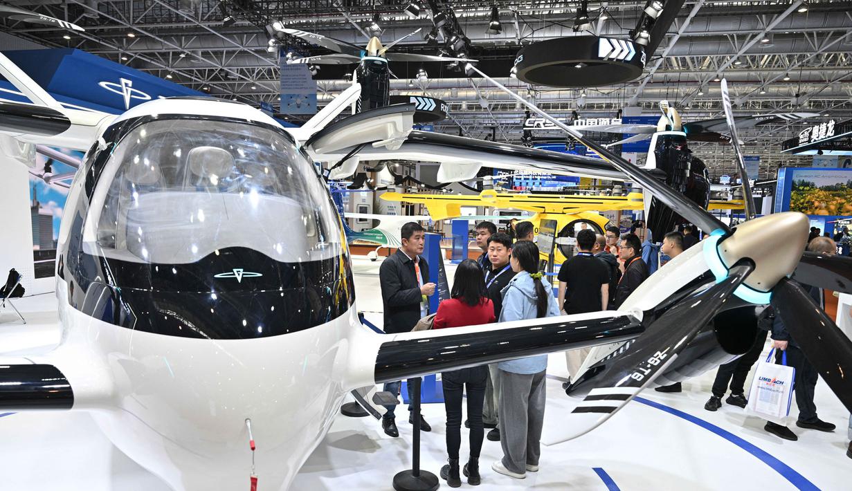 Partisipasi internasional juga mengalami kenaikan sebesar 29 persen dibandingkan edisi sebelumnya. Pengunjung terlihat di samping pesawat Zerog eVTOL model ZG-T6 di stan Zerog selama Aero Asia 2025 di Zhuhai, Provinsi Guangdong, Tiongkok selatan, pada Kamis 27 November 2025. (Hector RETAMAL/AFP)