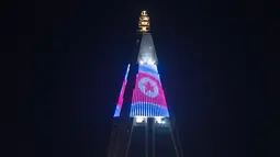Gambar bendera Korea Utara yang ditampilkan di puncak hotel Ryugyong di kota Pyongyang, Korea Utara (9/4). (AFP Photo/Ed Jones)