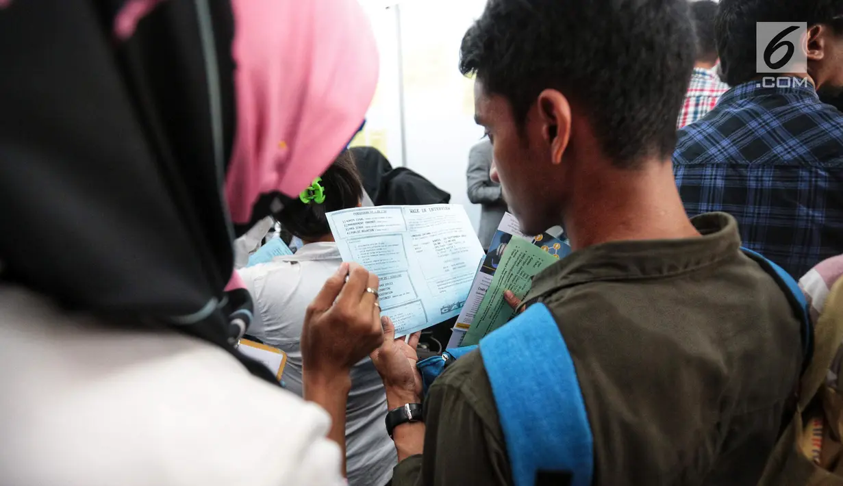 Pencari kerja menyiapkan dokumen saat Job Fair di Istora GBK, Jakarta, Rabu (19/9). Job Fair bertajuk Jakarta spektakuler "Job for Career" diikuti lebih dari 120 perusahaan BUMN, swasta skala nasional maupun internasional. (Liputan6.com/Faizal Fanani)