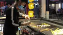 Seorang pedagang menjual kudapan di jalur pejalan kaki di Kunming, Provinsi Yunnan, China barat daya, pada 15 Maret 2020. Pemerintah Kota Kunming telah mengizinkan restoran-restoran untuk membuka kembali layanan makan di tempat di bawah upaya ketat pencegahan COVID-19. (Xinhua/Ding Yiquan)