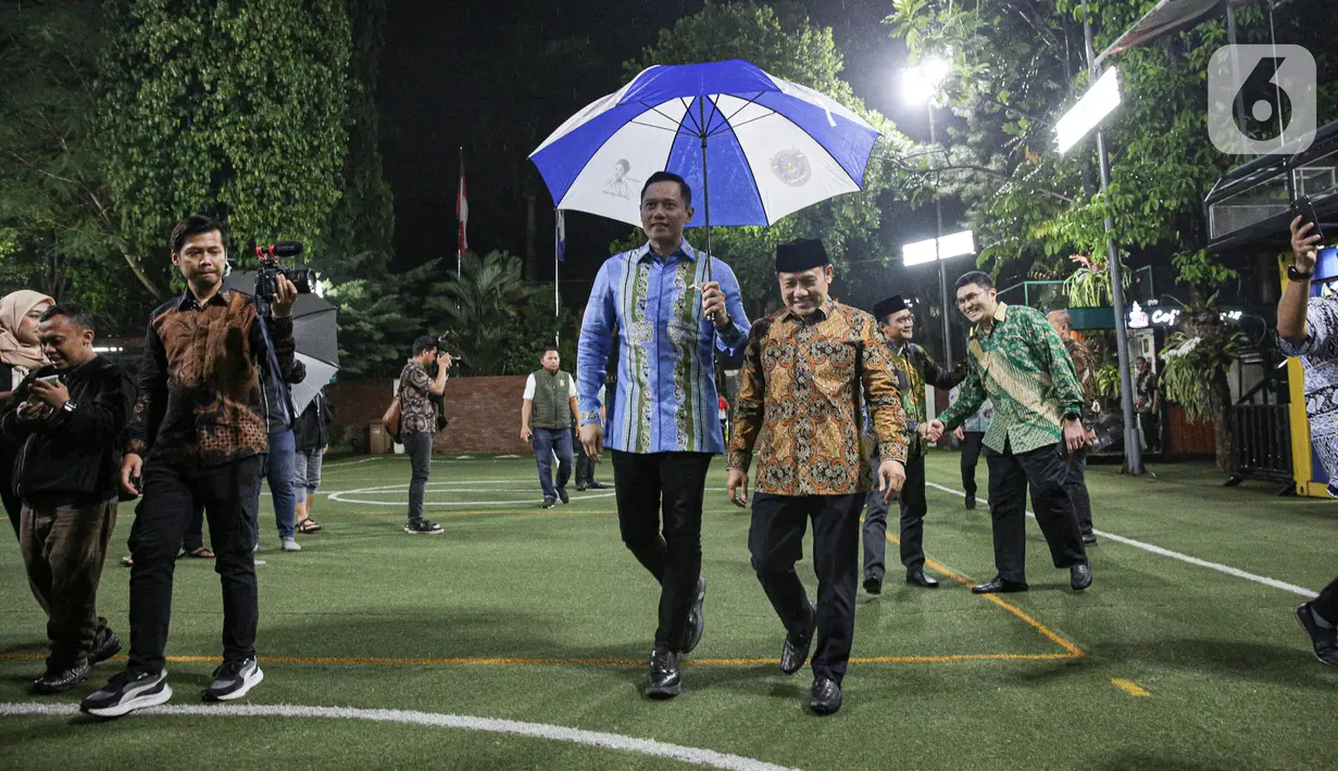 Suasana hujan kecil membuat AHY memayungi Cak Imin saat menerima kedatangannya. (Liputan6.com/Faizal Fanani)