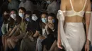 Para peserta mengenakan masker wajah untuk melindungi diri dari COVID-19 saat menonton model menampilkan kreasi perancang busana dari Finelycup dalam China Fashion Week di Beijing, China, Selasa (7/9/2021). (AP Photo/Mark Schiefelbein)