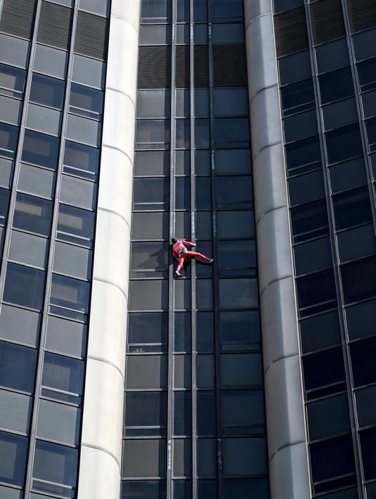 Alain Robert, pendaki bangunan pencakar langit asal Prancis memanjat Menara Montparnasse di Paris, Prancis, Rabu (12/10/2022). Alain Robert yang dikenal sebagai Spiderman Prancis itu kembali beraksi dengan memanjat Menara Montparnasse yang memiliki ketinggian 210 meter. (Bertrand GUAY/AFP)