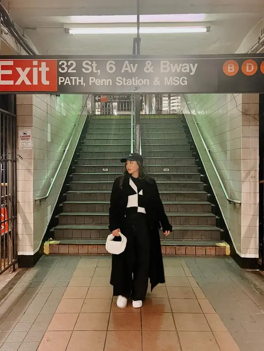 Potret OOTD fashionable Jessica Mila saat liburan mengenakan outfit serba hitam. Sweater bermotif abstrak hitam-putih, ditumpuknya dengan long coat hitam, dan dipadu dengan celana panjang hitam. Ia mempermanis penampilannya dengan topi, sneakers, dan handbag putih. [Foto: Instagram/jsmila]