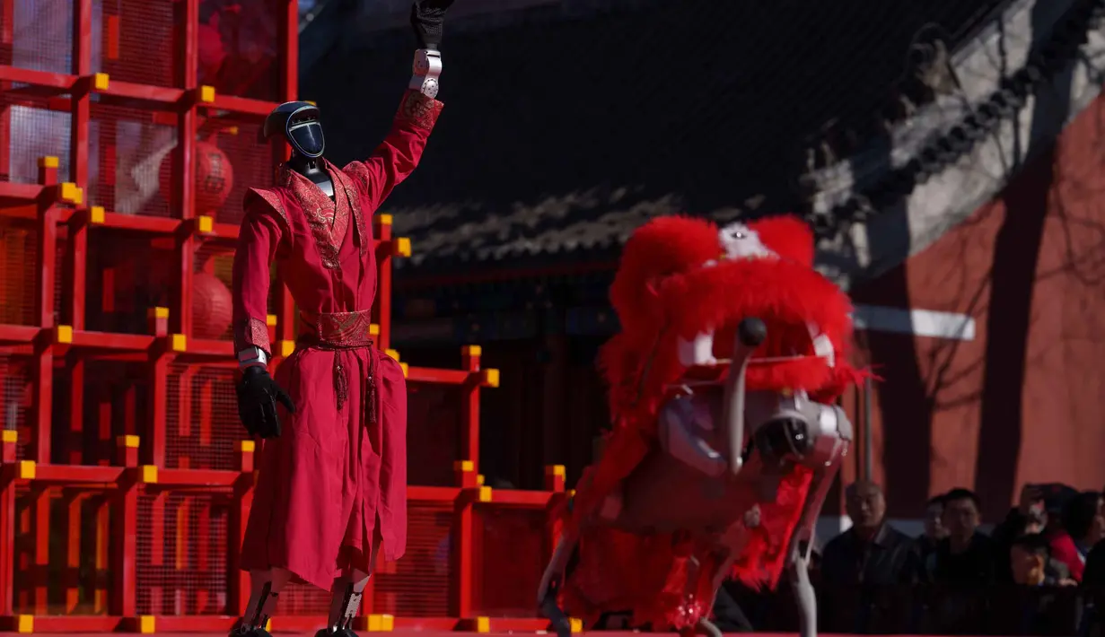 Pertunjukan ini merupakan bagian dari tren "AI Temple Fair". Tampak dalam foto, sebuah robot humanoid dengan pakaian merah meriah memberi isyarat di atas panggung sementara robot berkaki empat yang dilengkapi kepala singa bergerak di latar depan selama hari kedua perayaan Tahun Baru Imlek 2577 Kongzili di sebuah pekan raya kuil di Beijing pada Rabu 18 Februari 2026. (AP Photo/Vincent Thian)