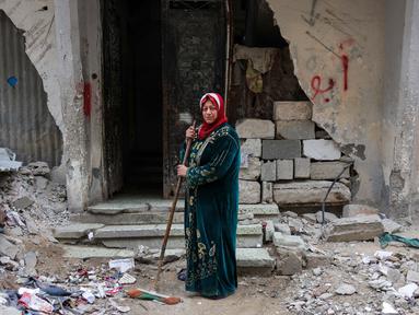 Shahira Sammour, 49 tahun, berpose di depan rumahnya yang hancur di Jabalia, Jalur Gaza utara, pada 9 Februari 2025. (Bashar TALEB/AFP)