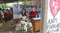 Petugas kesehatan menyuntikkan vaksin COVID-19 kepada warga Pancoran Buntu II di Pancoran, Jakarta, Jumat (10/12/2021). Sebanyak 23 warga Pancoran Buntu II yang termasuk kelas golongan menengah ke bawah menerima vaksin untuk menciptakan kekebalan kelompok. (Liputan6.com/Herman Zakharia)
