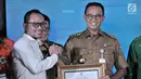 Gubernur DKI Jakarta Anies Baswedan (kanan) menerima penghargaan dari Menteri Ketenagakerjaan Hanif Dhakiri (kiri) dalam Indeks Pembangunan Ketenagakerjaan (INTEGRA) 2018 di Kantor Kemnaker, Jakarta, Senin (19/11). (Merdeka.com/Iqbal Nugroho)