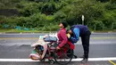 Migran Venezuela, Jefferson Alexis dan ayahnya, Jose Agustin Lopez, duduk di kursi roda, beristirahat ketika melakukan perjalanan yang menghubungkan Cucuta dan Pamplona di Norte de Santander Department, Kolombia, 15 September 2018. (AFP/SCHNEYDER MENDOZA)