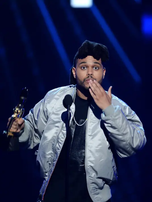 Setelah memberikan sambutan dan ucapan terimakasih, The Weeknd melambungkan ciuman untuk para penggemarnya. (AFP/Bintang.com)