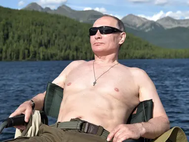 Foto yang dirilis oleh layanan pers Kremlin pada hari Sabtu, 5 Agustus 2017, Presiden Rusia Vladimir Putin beristirahat setelah memancing selama liburan mini di kawasan Siberia Tyva. (Alexei Nikolsky / Sputnik, Foto Kolam Kremlin via AP)