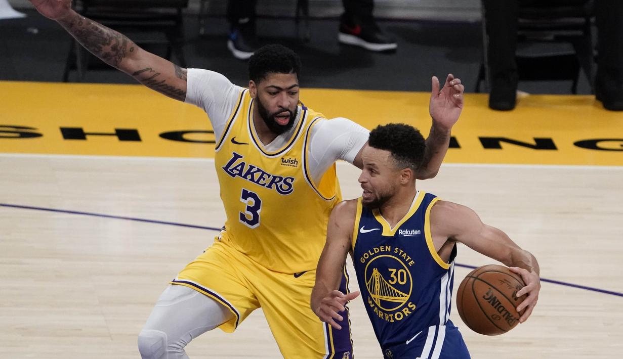 Pebasket Golden State Warriors Stephen Curry (kanan) berupaya melewati hadangan pebasket LA Lakers Anthony Davis dalam pertandingan NBA di Staples Center,  Los Angeles, California, Amerika Serikat, Senin (18/1/2020). (AP Photo/Jae C. Hong)