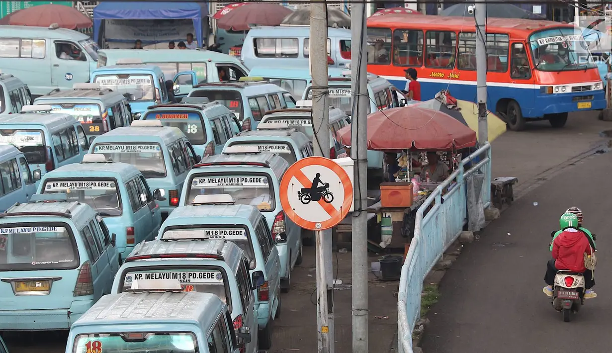 Pengendara sepeda motor melintasi jalur angkutan umum di Terminal Kampung Melayu, Jakarta, Rabu (6/2). Sejumlah pengendara nekat menerobos masuk terminal untuk memotong jalur guna memersingkat waktu tempuh. (Liputan6.com/Immanuel Antonius)