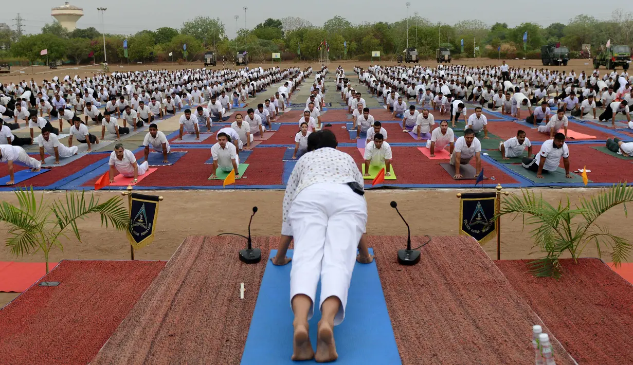 Ribuan personel Angkatan Darat India melakukan senam yoga di Ahmedabad, India, Senin (20/6). Kegiatan ini untuk memeriahkan perayaan Hari Yoga Internasional. (AFP PHOTO/Sam Panthaky)