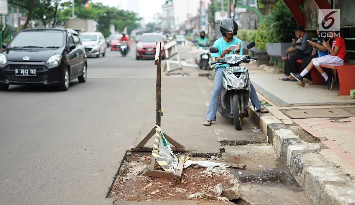 Kendaraan melintas di samping bekas galian proyek yang tidak tuntas pengerjaannya di Jalan Margonda Raya, Depok, Jawa Barat, Kamis (9/5/2019). Kondisi jalan yang diabaikan selama beberapa bulan terakhir tersebut memersempit dan mengganggu aktivitas warga. (Liputan6.com/Immanuel Antonius)