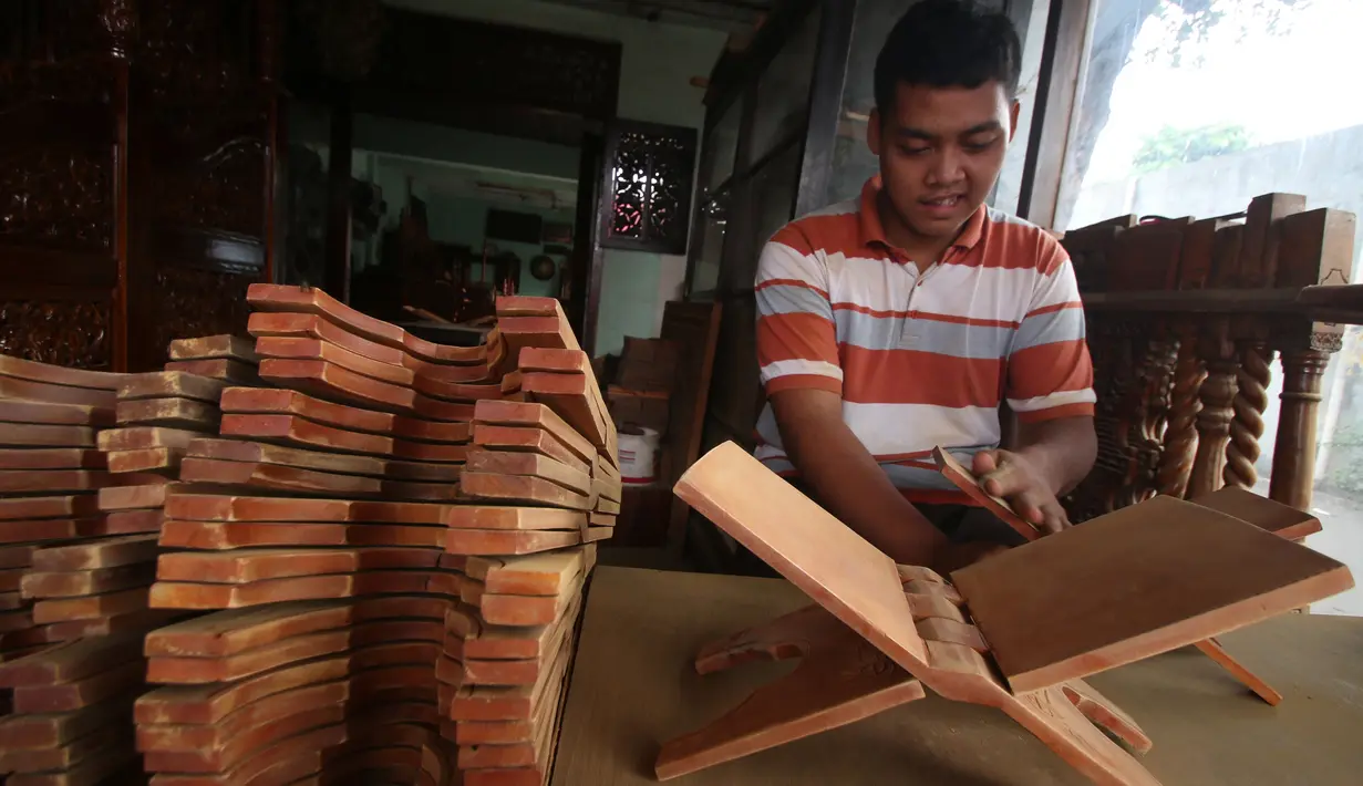 Pekerja menghaluskan kayu yang akan dibuat rekal Al Quran atau tatakan untuk Al Quran di kawasan Klender, Jakarta, Senin (5/6). Mayoritas pemesanan rekal Al Quran berasal dari masjid di kawasan Jakarta. (Liputan6.com/Angga Yuniar)