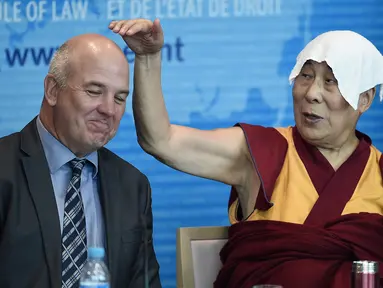 Dalai Lama menunjuk ke arah Dewan Komisaris Eropa untuk Hak Asasi Manusia, Nils Muiznieks saat ia pidato di Dewan Eropa di Strasbourg, Perancis, Kamis (15/9). Ini adalah kunjungan Eropa pertama Dalai Lama setelah lima tahun. (AFP PHOTO/Frederick Florin)