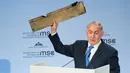 PM Israel Benjamin Netanyahu menunjukkan benda yang diduga potongan pesawat tak berawak Iran yang ditembak jatuh di wilayah udara Israel saat pidato dalam Konferensi Keamanan Munich (18/2). (AFP/ MSC Munich Security Conference / Lennart Preiss)