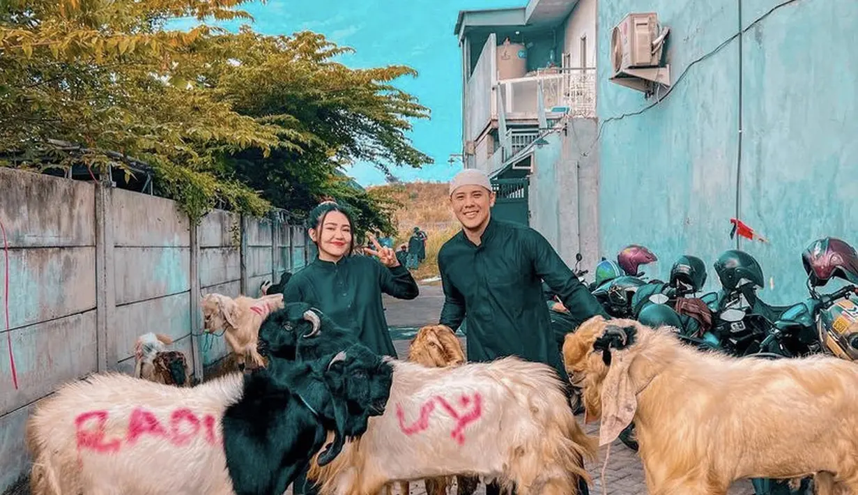Via Vallen juga kompak mengenakan baju hitam bersama sang suami. Mereka pun berfoto di depan hewan kurbannya. @viavallen