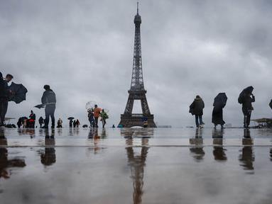 Pengunjung berjalan di Esplanade du Trocadero dengan latar belakang Menara Eiffel, yang ditutup untuk umum pada hari keempat pemogokan stafnya, di Paris pada 22 Februari 2024. (Dimitar DILKOFF/AFP)