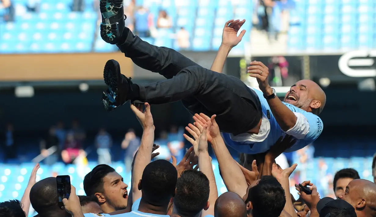 Manajer Manchester City Pep Guardiola dilemparkan ke udara oleh para pemainnya usai melawan Huddesfiel dalam pertandingan Liga Inggris di Etihad Stadium (6/5). (Martin Rickett/PAvia AP)