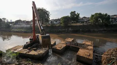 Alat berat melakukan pengerukan tumpukan sisa lumpur dan tanah yang menumpuk di pinggir kali Ciliwung, Jakarta, Kamis (28/7). Tumpukan tanah dan lumpur sisa dari pengerukan kali Ciliwung mulai dibersihkan.(Liputan6.com/Yoppy Renato)