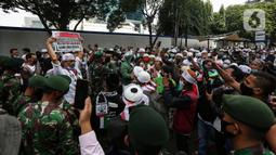 Aksi prajurit TNI menghalau massa yang hendak menggelar demonstrasi 1812 di sekitar Istana Negara, Jakarta, Jumat (18/12/2020). Aparat yang bertugas mencoba memberi tahu massa Aksi 1812 mengingat Jakarta masih dalam situasi pandemi Covid-19. (Liputan6.com/Johan Tallo)