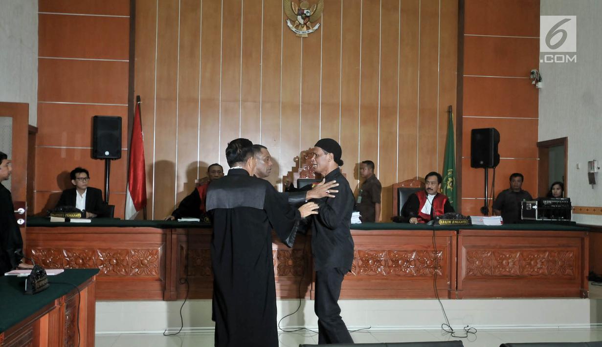 Terdakwa Hercules Rosario Marshal mengamuk saat memasuki ruang sidang akibat dikawal polisi di PN Jakarta Barat, Rabu (27/3). Hercules terbukti melakukan penyerobotan secara melawan hukum yang pidananya diatur dalam Pasal 167 KUHP juncto Pasal 55 ayat 1 ke-1 KUHP. (merdeka.com/Iqbal S. Nugroho)