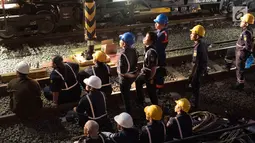 Petugas melihat proses evakuasi gerbong KRL Commuter Line dengan nomor KA 1722 jurusan Jatinegara - Bogor di kawasan Kebon Pedes, Bogor, Jabar Minggu (10/3). Proses evakuasi menggunakan crane dari Bandung. (Liputan6.com/Immanuel Antonius) 