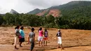 Sejumlah berjalan melintasi salah satu wilayah pemukiman yang terkena longsor di Desa Elangipitiya, Aranayaka, Sri Lanka (19/5). Bencana tanah longsor disebabkan oleh hujan lebat selama berhari-hari di Sri Lanka. (REUTERS/Dinuka Liyanawatte)