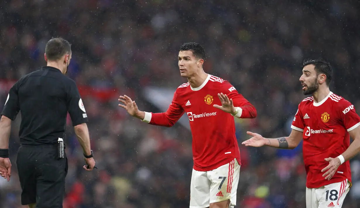 Pemain Manchester United Cristiano Ronaldo (tengah) dan Bruno Fernandes berbicara kepada wasit Stuart Attwell saat melawan Southampton pada pertandingan sepak bola Liga Inggris di Stadion Old Trafford, Manchester, Inggris, 12 Februari 2022. Pertandingan berakhir dengan skor 1-1. (AP Photo/Jon Super)