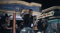 Gelandang Arema FC, Julian Guevara, membalas sambutan Aremania dengan membawa trofi Piala Presiden 2024 ke kota Malang, Senin (05/08/2024). (Bola.com/Iwan Setiawan)