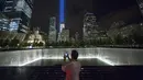 Seorang pengunjung mengabadikan lampu sorot dipancarkan ke langit dari World Trade Center (WTC) kota New York, AS, (9/9/2015). Acara Tribute in Light memperingati 14 tahun tragedi terorisme 11 September di Amerika Serikat. (REUTERS/Andrew Kelly)