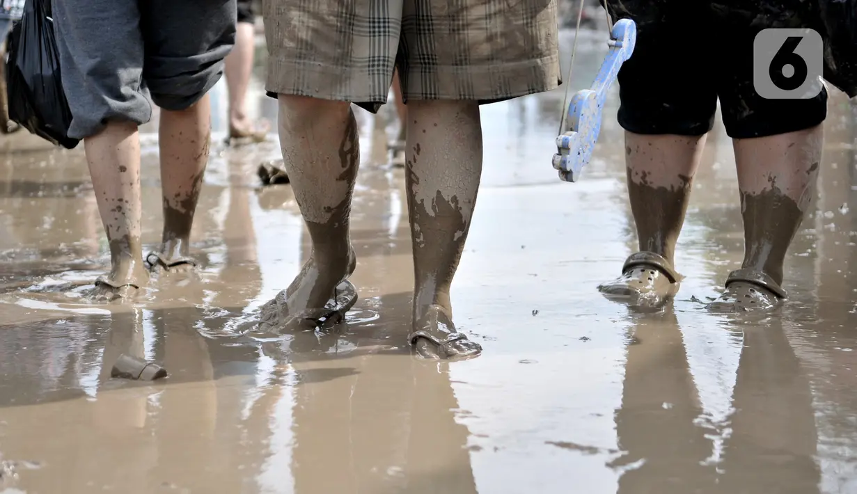 Kondisi kaki warga saat membersihkan lumpur akibat banjir di Perumahan Pondok Gede Permai, Jatiasih, Bekasi, Jawa Barat, Kamis (2/1/2020). Terjangan banjir setinggi lima meter tersebut menyisakan lumpur dan sampah yang memenuhi seluruh kompleks perumahan. (merdeka.com/Iqbal Nugroho)