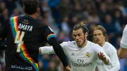 Penyerang Real Madrid, Gareth Bale berusaha melewati pemain Rayo Vallecano pada lanjutan liga Spanyol di Santiago Bernabeu (20/12). Real Madrid menang telak atas Rayo Vallecano dengan skor 10-2. (AFP/curto DE LA TORRE)