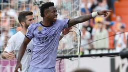 Striker Real Madrid, Vinicius Junior menunjuk oknum suporter Valencia yang terus mengejeknya dengan ejekan rasis pada laga pekan ke-35 Liga Spanyol 2022/2023 di Mestalla Stadium, Valencia, Senin (22/5/2023) dini hari WIB. (AFP/Jose Jordan)