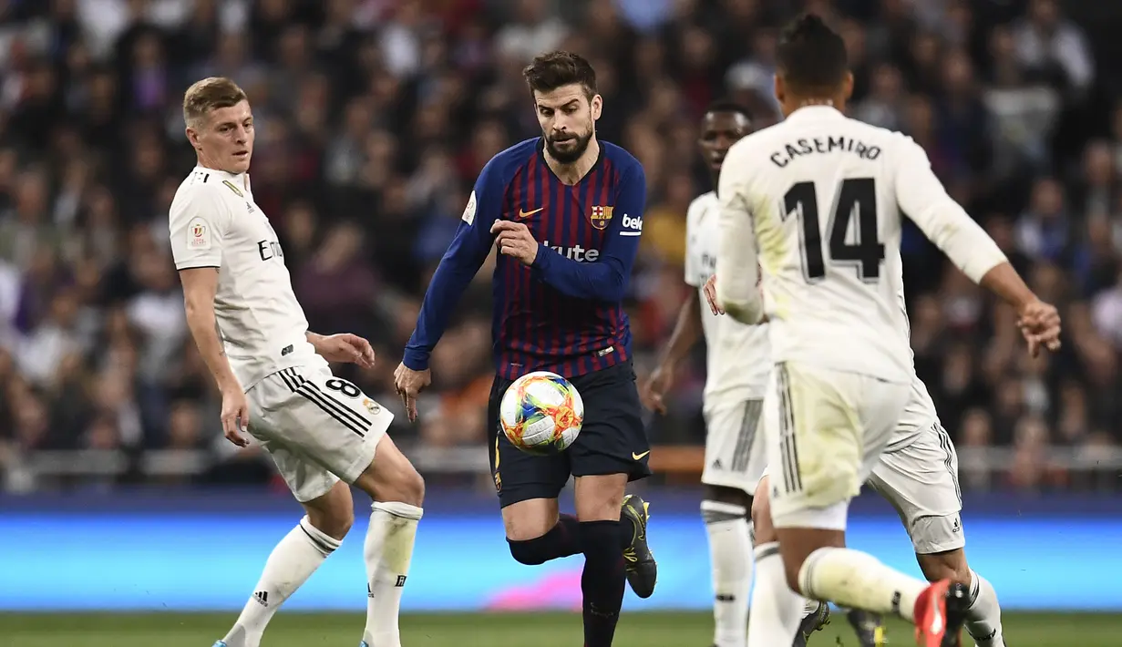 Aksi Gerard Pique melewati Toni Kross pada laga semfinal Copa Del Rey yang berlangsung di stadion Santiago Bernabeu, Madrid, Kamis (28/2). Barcelona menang 3-0 atas Real Madrid. (AFP/Oscar Del Pozo)