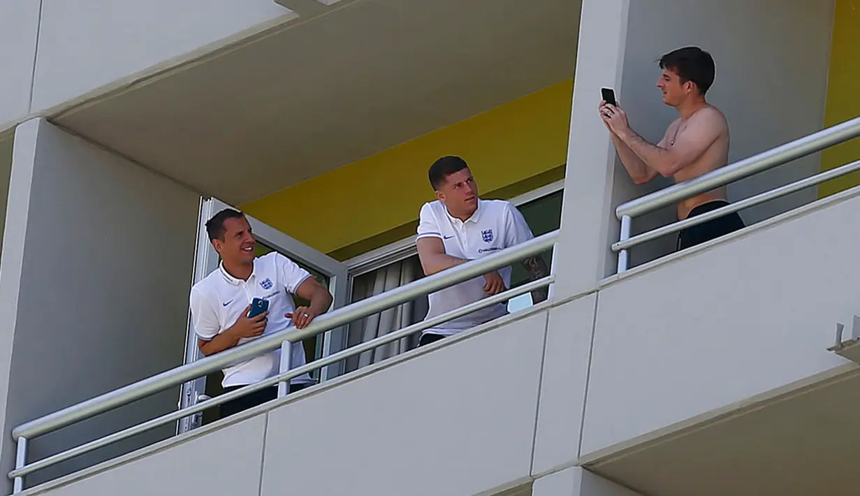 Dua pemain Timnas Inggris, Phil Jagielka (kiri) dan Ross Barkley terlihat asyik berfoto di balkon hotel tempat mereka menginap di Rio de Janeiro, Brasil, (8/6/2014). (REUTERS/Eddie Keogh)
