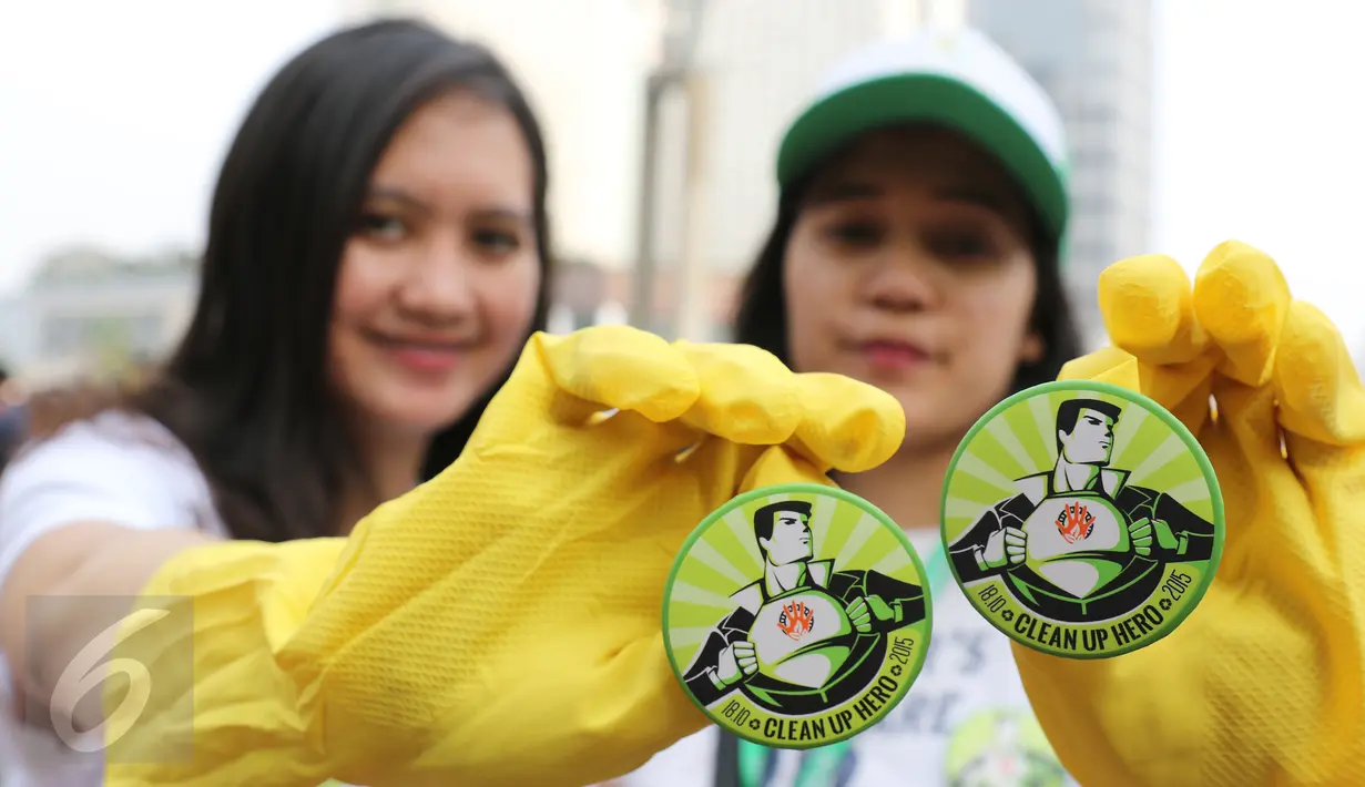 Dua orang relawan menunjukkan pin Clean Up Jakarta Day (CUJD) 2015 di Bunderan Hotel Indonesia, Jakarta, minggu (18/10/2015). Sebanyak 15.000 relawan mengikuti kegiatan Clean Up Jakarta Day 2015. (LIputan6.com/Herman Zakharia)