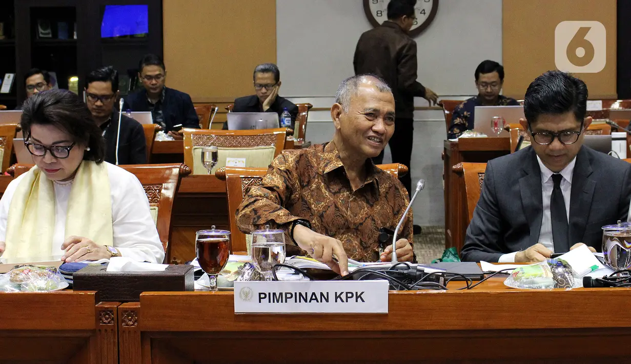 Ketua KPK Agus Rahardjo (tengah) berbincang dengan Wakil Ketua KPK La Ode Muhammad Syarif didampingi Basaria Pandjaitan saat akan rapat dengan Komisi III DPR RI di kompleks Parlemen, Jakarta, Rabu (27/11/2019). Rapat membahas evaluasi kinerja KPK masa kerja 2015-2019. (Liputan6.com/Johan Tallo)